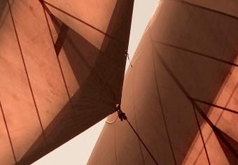 Poster Sea Breeze - seascape of the front of a sailboat in sepia tones against the sky